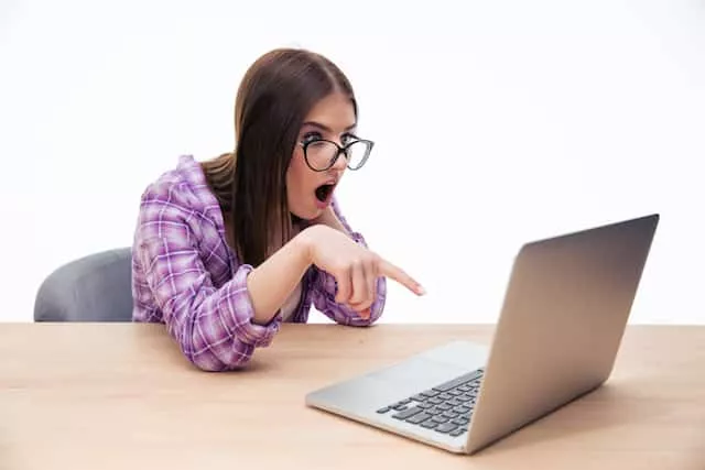 Surprised female student sitting with laptop